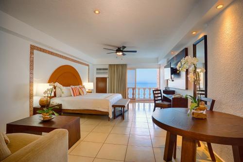 a hotel room with a bed and a living room at Costa Sur All Inclusive Resort in Puerto Vallarta