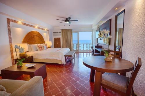 Habitación de hotel con cama y balcón en Costa Sur Resort & Spa en Puerto Vallarta