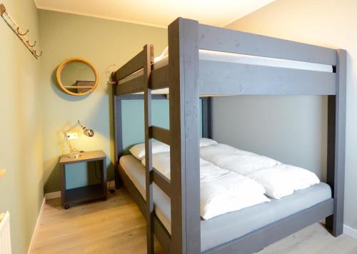 a bedroom with two bunk beds and a mirror at Kappeberg Lodge in Winterberg
