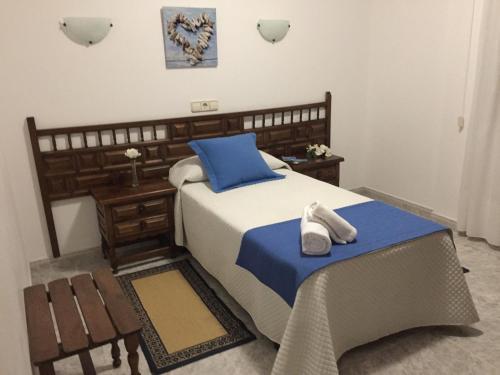 a bedroom with a bed with two white shoes on it at Hotel Florida in A Lanzada