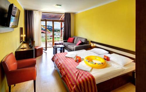 a hotel room with a bed with a bowl on it at Wellness Hotel Bešeňová in Bešeňová