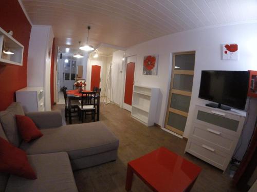 a living room with a couch and a tv and a table at Ideal Sejour - Le Mont-Dore in Le Mont-Dore