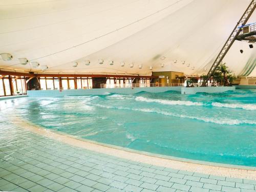 a large swimming pool with water in a building at Wellness Hotel Bešeňová in Bešeňová