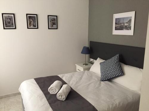 a bedroom with a bed with two towels on it at Buccaneers Boutique Guest House in St Paul's Bay