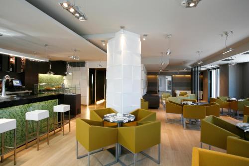 a restaurant with green chairs and a white column at Hotel Bienestar Moaña in Moaña