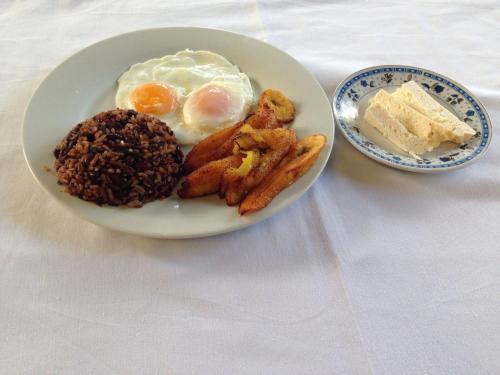 a plate of breakfast food with eggs and bread at Hotel Ecológico Tierra Blanca in Moyogalpa