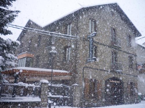 a snow covered building with a traffic light in front of it at Hostal Vall D'Aneu by Arcas & Sambola in Esterri d'Àneu