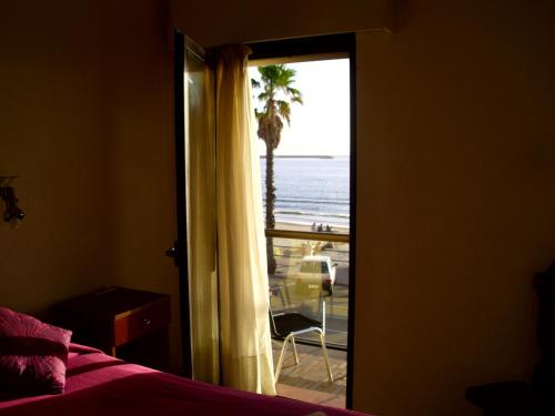 a bedroom with a door open to a view of the ocean at Hotel City Piriápolis in Piriápolis