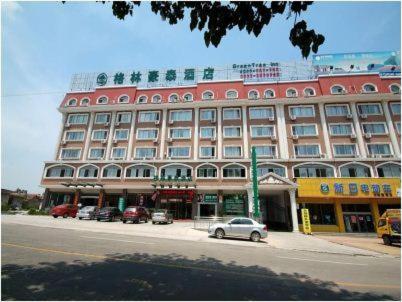 a large building with cars parked in front of it at GreenTree Inn Rizhao West Station Suning Plaza in Rizhao