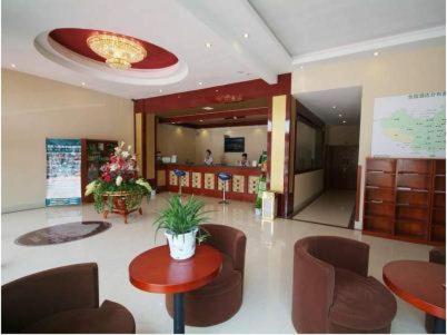 a lobby with chairs and a table and a counter at GreenTree Inn Rizhao West Station Suning Plaza in Rizhao