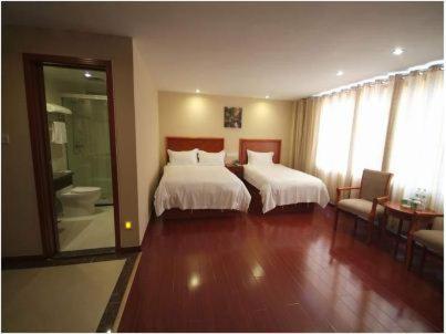 a hotel room with two beds and a bathroom at GreenTree Inn Rizhao West Station Suning Plaza in Rizhao