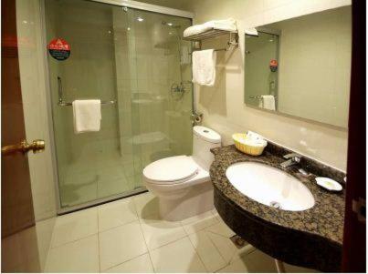 a bathroom with a toilet and a sink and a shower at GreenTree Inn Rizhao West Station Suning Plaza in Rizhao