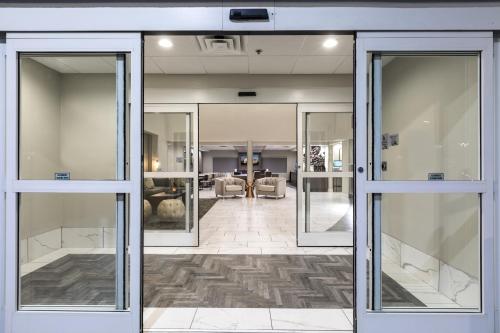 an open glass door to a lobby with a living room at Wingate Augusta Washington Road by Wyndham in Augusta