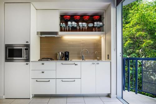 a kitchen with white cabinets and a sink at Perfect luxury for 2, Noosa Heads in Noosa Heads