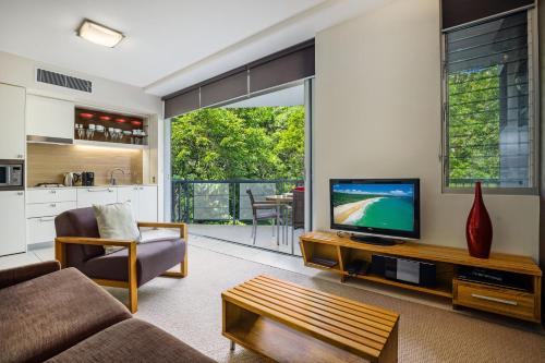 a living room with a couch and a television at Perfect luxury for 2, Noosa Heads in Noosa Heads