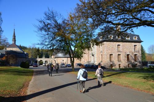 a group of people walking down a sidewalk in front of a building at B&B Nord Sud in Salmchâteau