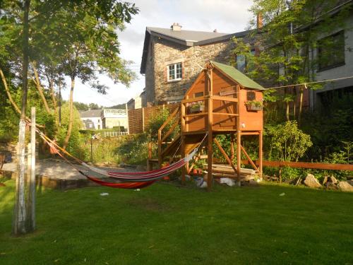 a tree house with a hammock in a yard at B&B Nord Sud in Salmchâteau