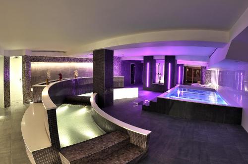 a house with a swimming pool with purple lighting at Hotel Kandahar in Pas de la Casa