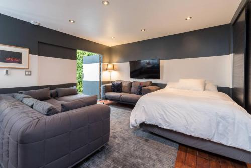 ein Schlafzimmer mit einem großen Bett und einer Couch in der Unterkunft Palo Alto Cottage by Stanford & Tech Companies in Palo Alto