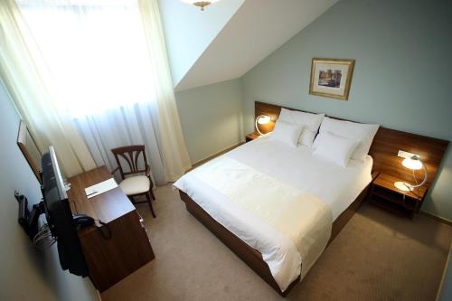 a bedroom with a bed and a television in it at Hotel Maroon in Zagreb