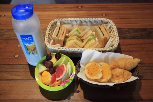 two baskets of sandwiches and fruit and a bottle of water at We Love B&B in Anping