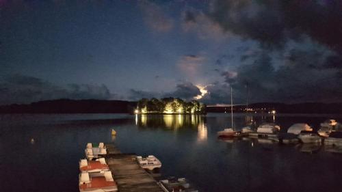 a dock with boats in the water at night at Hotel Restaurant La Caravelle in Peyrat-le-Château
