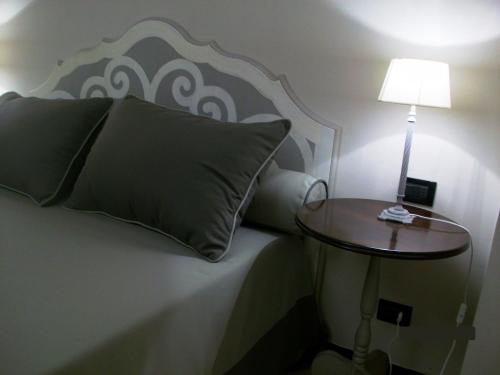 a bed with a pillow and a table with a lamp at Da ö Vittorio SRL in Recco