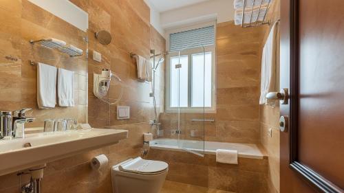 a bathroom with a toilet and a sink and a shower at Hotel Maroon in Zagreb