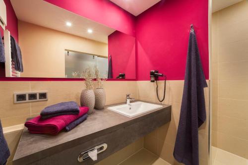 baño con lavabo y pared rosa en Hotel Raphael im Allgäu, en Kempten