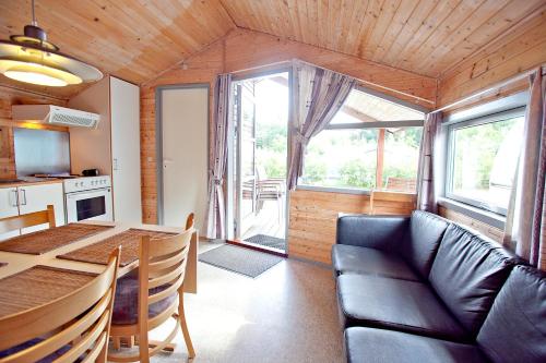 a living room with a table and a couch at Svalereden Strand Camping Cottages in Frederikshavn