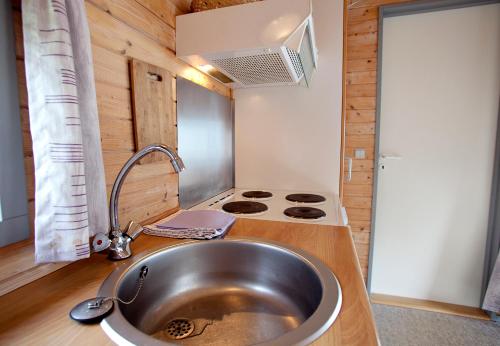 a kitchen with a sink and a stove at Svalereden Strand Camping Cottages in Frederikshavn