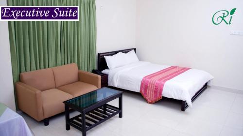 a bedroom with a bed and a chair and a table at Restinn Hotel in Maulvi Bāzār