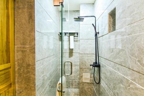a shower with a glass door in a bathroom at The blue mountains on the moon in Shangri-La