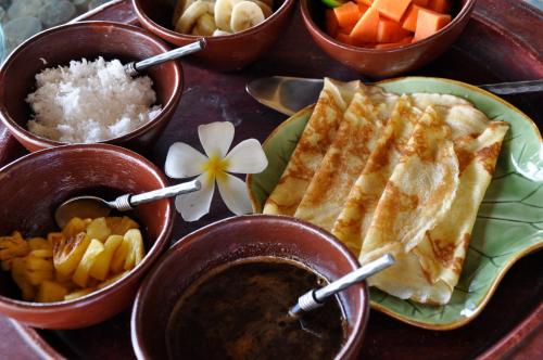 ein Tablett mit Reis, Karotten und anderen Speisen in der Unterkunft The Longhouse, Jimbaran - Bali in Jimbaran