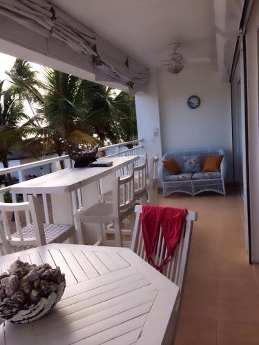 a balcony with a table and chairs and a couch at Apartamento Juan Dolio in Juan Dolio