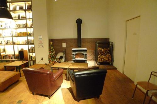 a living room with a wood stove in a room at Hotel Potmum Sapporo in Sapporo