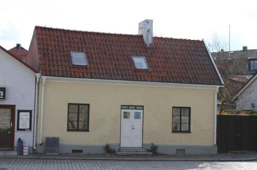 a small yellow house with a red roof at Casa Kruttornet & Villa Fiskarporten in Visby