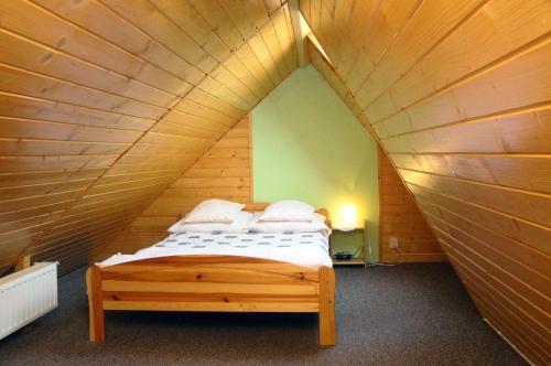 1 dormitorio con 1 cama en una habitación de madera en Willa Anna, en Zakopane