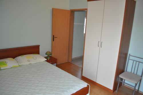 a bedroom with a bed and a closet and a chair at Apartments Zora in Vis