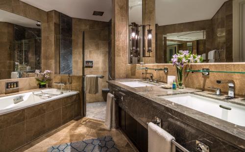 a bathroom with two sinks and a large mirror at Four Seasons Hotel Singapore in Singapore