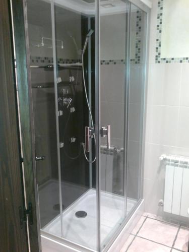 a shower with a glass door in a bathroom at La Cerca de Doña Jimena in Modúbar de San Cibrián