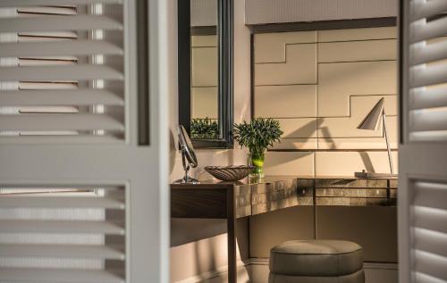 a room with a desk and a mirror at Four Seasons Hotel Singapore in Singapore
