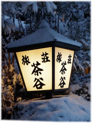 a lantern with chinese writing on it in the snow at Ryoso Chatani in Kyoto