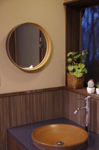 a bathroom with a wooden sink and a mirror at Ryoso Chatani in Kyoto