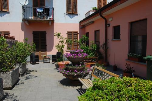 a courtyard with a bench and flowers and a building at Albergo Visconti in Cremona