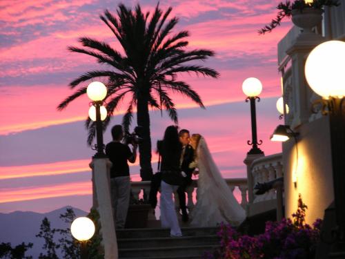 a bride and groom standing on the steps of a building with a sunset at Casa de los Bates in Motril