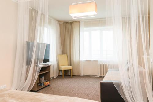 een slaapkamer met een bed, een tv en een raam bij Cozy apartment in Cesis in Cēsis