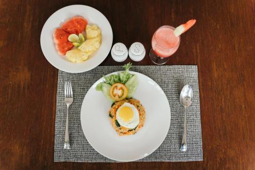 a table with two plates of food and a drink at Villa Raka Managed by Manara in Legian