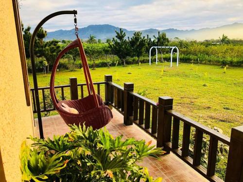 a porch with a swing and a field with a park at 台東鹿野森活 訂房來電付訂確認 in Ruiyuan