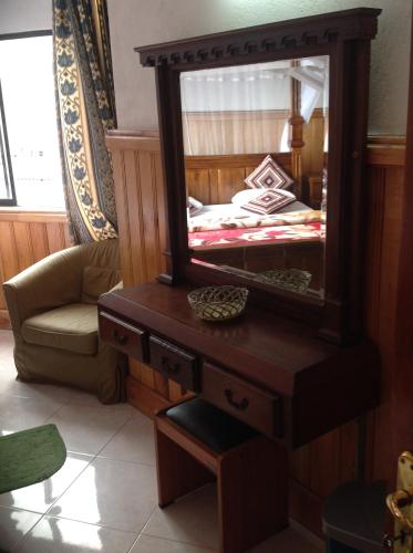 a mirror on a wooden dresser in a bedroom at Highcliffe Guest House in Haputale
